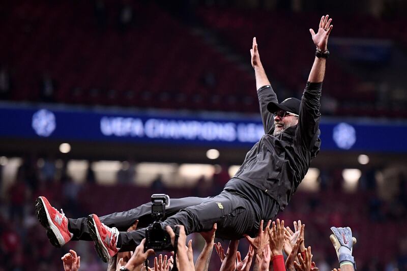 Klopp is thrown in the air as he celebrates with his players and staff. Getty