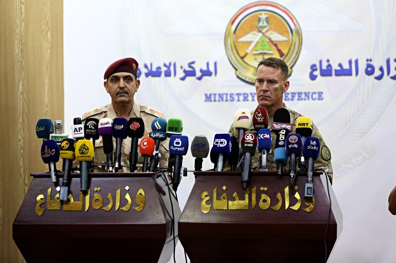 U.S. Army Colonel Ryan Dillon, Spokesman for Operation Inherent Resolve (OIR), the U.S.-led coalition against the Islamic State grou, right, speaks during a joint press conference with Gen. Yahya Rasool, an Iraqi military spokesman in the Ministry of Defense in Baghdad, Iraq, Thursday, Aug. 24, 2017. Dillon said Islamic State militants are "completely surrounded" in the town of Tal Afar and "are being killed." (AP Photo/Karim Kadim)