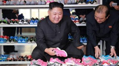 In contrast to the harsh rhetoric of the statement, Mr Kim was seen smiling during the shoe factory visit. Picture via KCNA.