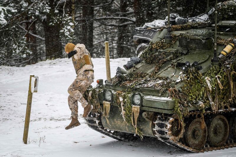 A Latvian soldier jumps off a military vehicle during Nato exercises in the country last year. AFP