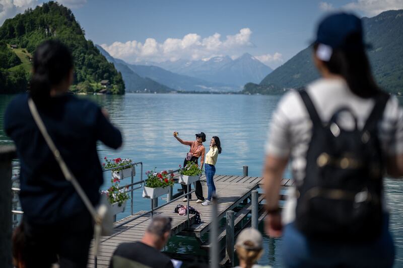 Tourists take a selfie on the pier by Lake Brienz