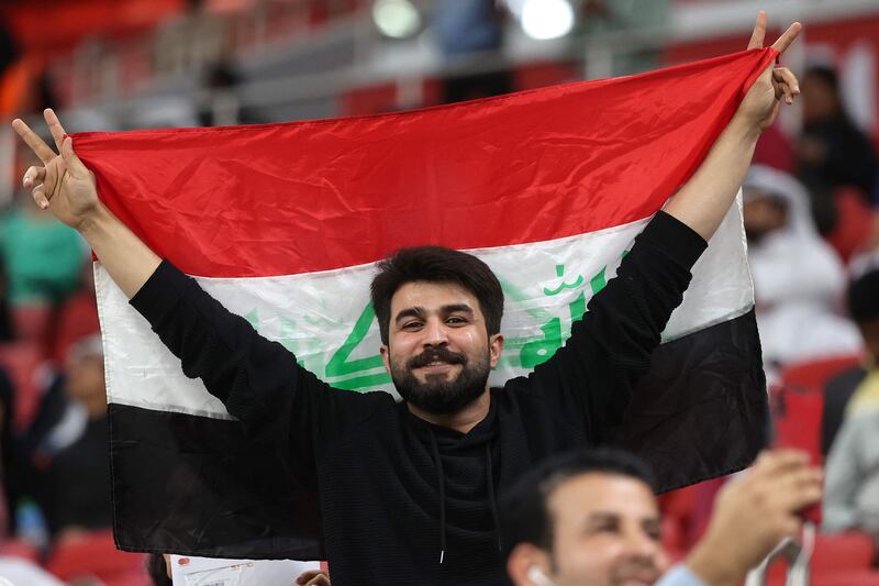 An Iraqi supporter waves the national flag ahead of the Fifa Arab Cup 2021 group A football match between Qatar and Iraq. AFP
