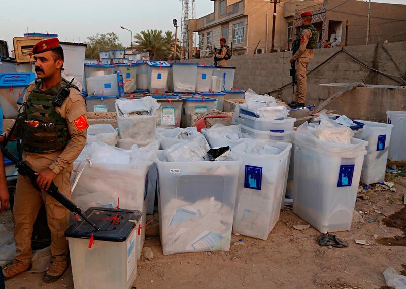 Iraqi security forces guard ballot boxes after a fire that broke out at Baghdad's largest ballot box storage site, where ballots from Iraq's May parliamentary elections are stored, in Baghdad, Iraq, Sunday, June 10, 2018. The ballots are part of a manual recount of votes, mandated in a law passed by the Iraqi parliament last Wednesday. (AP Photo/Karim Kadim)