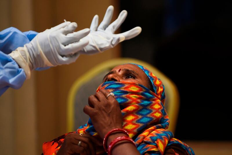 A health worker prepares to take a swab sample from a passenger for a rapid antigen tests (RAT) for the COVID-19 coronavirus at Ranip Bust Terminus in Ahmedabad.   AFP