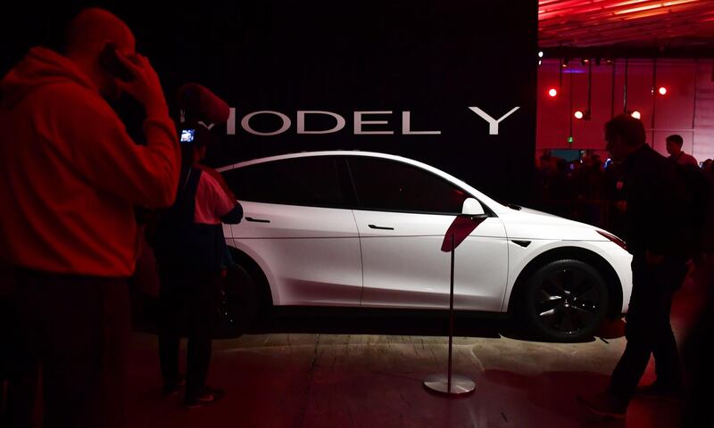 People view a model of the new Tesla Model Y. AFP