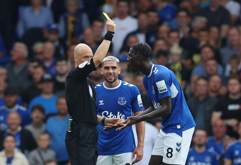 Everton's Amadou Onana is shown a yellow card by referee Anthony Taylor. Reuters