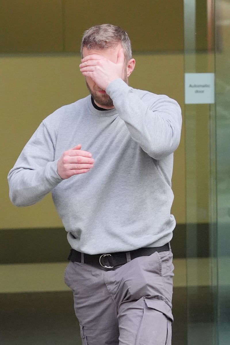 Mr Trickett covering his face as he leaves Westminster Magistrates' Court, central London on May 13. PA
