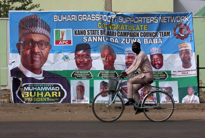 A cyclist drives pasts a campaign poster for President Muhammadu Buhari in a street after the postponement of the presidential election in Kano, Nigeria February 17, 2019. REUTERS/Luc Gnago