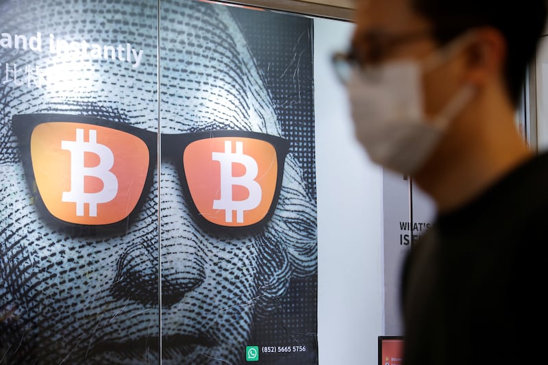 An advertisement for Bitcoin and cryptocurrencies is seen in Hong Kong. The cryptocurrency could break the $100,000 level next year, analysts say. Reuters