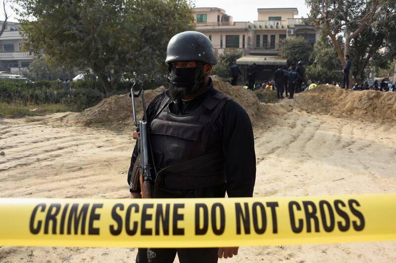 Armed police guard the cordoned-off crime scene. Reuters