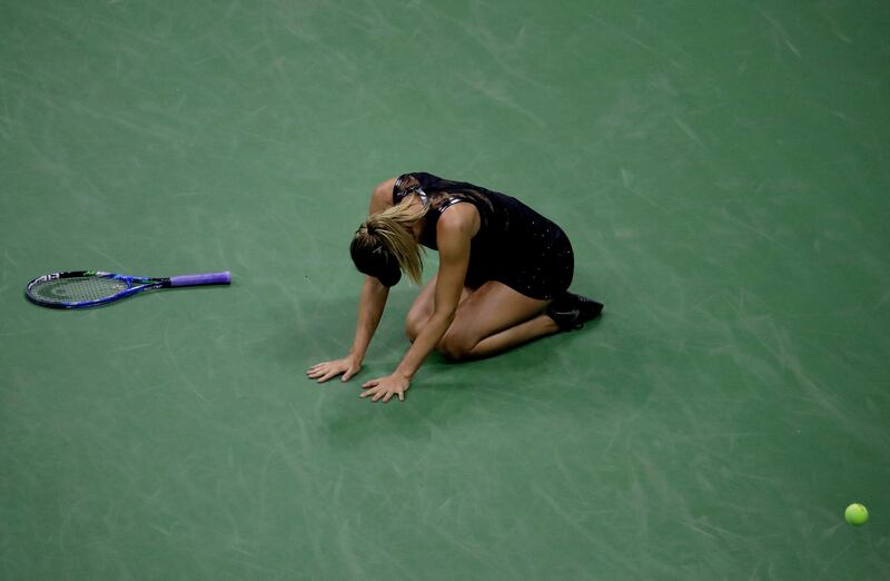 Maria Sharapova collapses to the court after deating Simona Halep. Julio Cortez / AP Photo