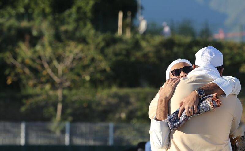 Men hug as people gather for prayers at the velodrome of Saint-Denis de la Reunion on the French island of Reunion in the Indian Ocean. Richard Bouhet / AFP Photo