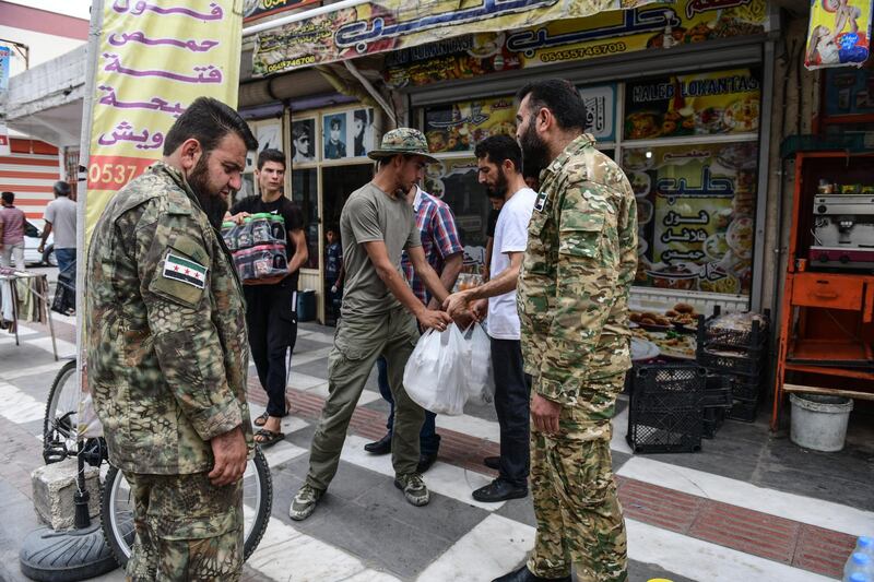 Members of Turkish-backed Free Syrian Army, a militant group active in parts of northwest Syria, load their goods after shopping from a market to their vehicle Akcakale, Turkey. Getty Images