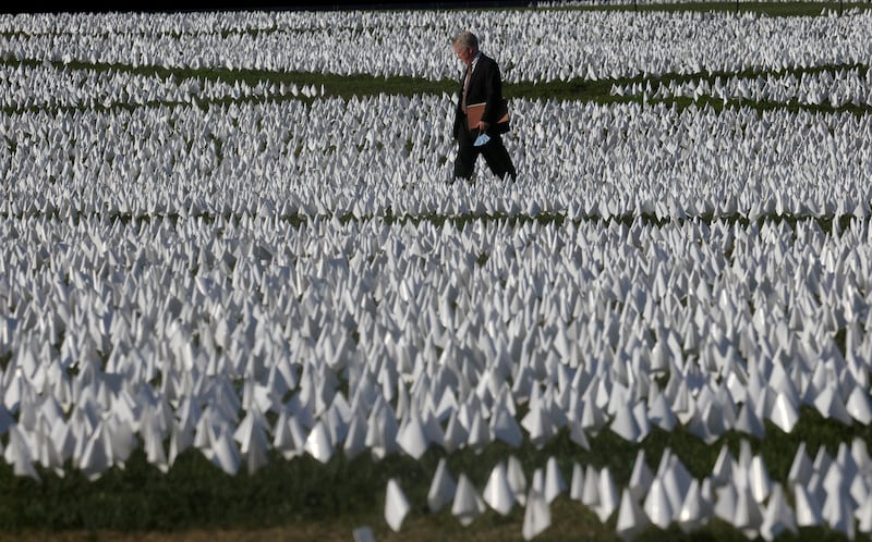 FILE PHOTO: People visit Suzanne Brennan Firstenberg's "In America: Remember", a memorial for Americans who died due to the coronavirus disease (COVID-19) as the national death toll nears 700,000, next to the Washington Monument in Washington, U.S., October 1, 2021. REUTERS/Leah Millis/File Photo