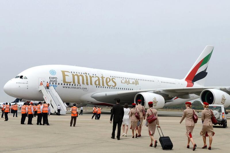 Indian ground staff and airline stewards gather near an Amirates Airbus A380, the world’s largest passenger airliner, on display for the India Aviation 2014 airshow. Noah Seelam / AFP