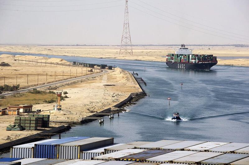 A Suez Canal Authority pilot vessel, centre, navigates a convoy of container ships as they pass southbound along the Suez Canal in Egypt. Kristian Helgesen / Bloomberg