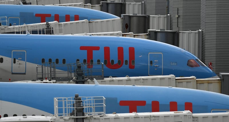 Aircraft grounded due to the COVID-19 pandemic, including planes operated by TUI are pictured on the apron at Manchester Airport in Manchester, north west England on May 1, 2020. - Irish low-cost carrier Ryanair said on Friday it planned to axe 3,000 pilot and cabin crew jobs, or 15 percent of staff, with air transport paralysed by coronavirus. Dublin-based Ryanair added in a statement that most of its flights would remain grounded until at least July and predicted it would take until summer 2022 at the earliest before passenger demand recovers. (Photo by Oli SCARFF / AFP)