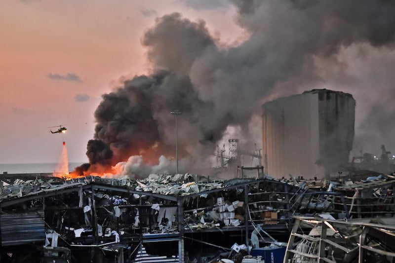 A helicopter puts out a fire at the scene of the explosion at the port of Lebanon's capital Beirut on August 4, 2020. AFP