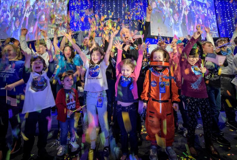 In this photo provided by NASA, New Horizons principal investigator Alan Stern, of the Southwest Research Institute in Boulder, Colo., center, celebrates with school children at the exact moment that the New Horizons spacecraft made the closest approach of Kuiper Belt object Ultima Thule, early Tuesday, Jan. 1, 2019, at Johns Hopkins University Applied Physics Laboratory in Laurel, Md. (Bill Ingalls/NASA via AP)