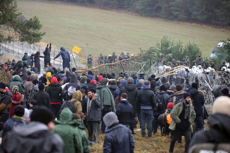 People gather at the EU border near Grodno, Belarus. AP