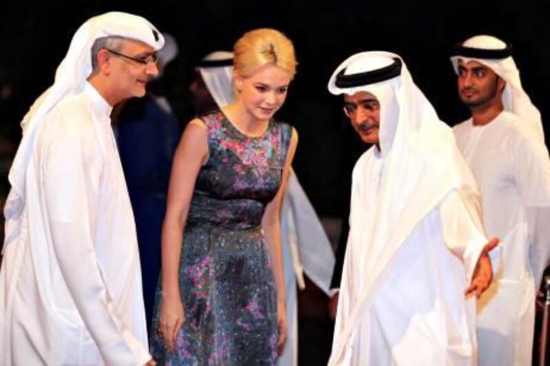 epa02491309 British actress Carey Mulligan (C) is greeted by Chairman of the event Abdel Hamid Jumaa (right) as she arrives at the opening ceremony of the Dubai International Film Festival (DIFF) at Madient Jumierah in Dubai, UAE, 12 December 2010. DIFF runs from 12 until 19 December 2010.  EPA/MOHAMED MESSARA *** Local Caption ***  02491309.jpg