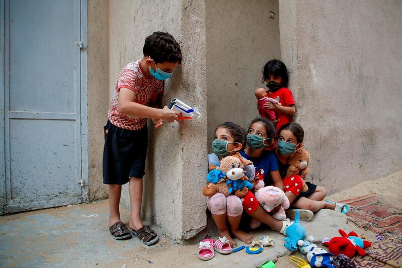 Palestinian children play outside their house in Gaza City. AFP
