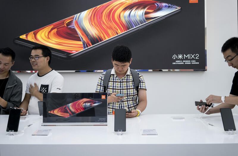 Attendees look at the Xiaomi Corp. Mi Mix 2 smartphone during a launch event in Beijing, China, on Monday, Sept. 11, 2017. Xiaomi introduced the latest versions of its Mi Mix devices developed with famed designer Philippe Starck. Photographer: Giulia Marchi/Bloomberg
