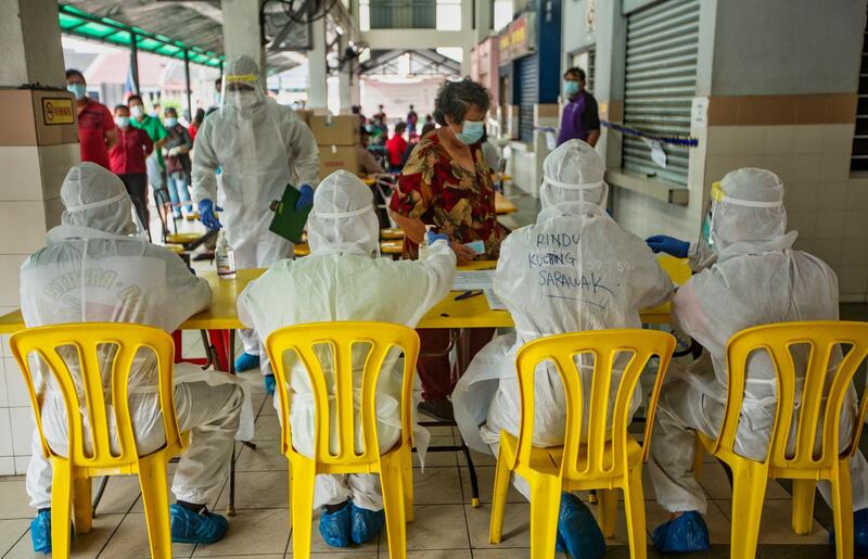 Malaysian health workers register traders before carrying out COVID-19 screenings at a wet market in Petaling Jaya near Kuala Lumpur, Malaysia. About 60 traders of Taman Megah morning wet market were undergoing COVID-19 screenings after one of them had tested positive for the coronavirus disease. The market was shut down for sanitisation work.  EPA