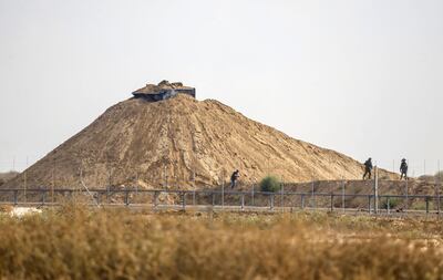 A picture taken from Khan Yunis shows Israeli soldiers inspecting the area around their observation post across the border fence with the southern Gaza Strip on August 1, 2019, following a firefight with a Palestinian. The Palestinian crossed into Israel from Gaza and shot at troops, setting off a firefight in which he was killed and three Israeli soldiers were wounded in the early hours of today, the army said. An Israeli tank targeted a Hamas military post after the incident which began at around 2:00 am, Israel's military said.
 / AFP / SAID KHATIB
