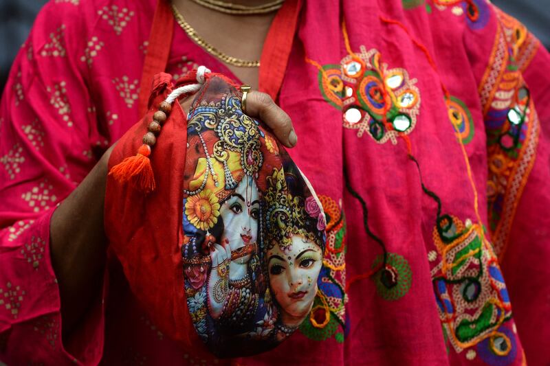 A devotee holds a bag containing prayer beads for the occasion. AFP