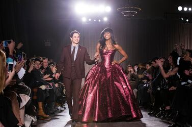 FILE - In this Feb. 16, 2015, file photo, designer Zac Posen and model Naomi Campbell greet the crowd after his Fall 2015 collection is modeled during Fashion Week, in New York. Posen is shutting down his namesake label. Posen, 39, said he was “deeply saddened that the journey of nearly 20 years has come to an end.” He launched his label in 2001. (AP Photo/John Minchillo, File)