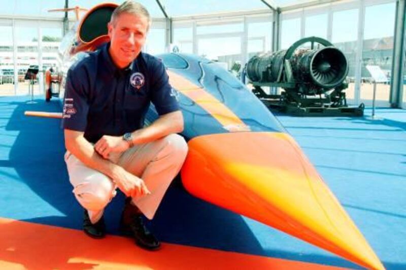 Wing Commander Andy Green OBE next to a model of the Bloodhound supersonic car at the Farnborough International Airshow, Hampshire.