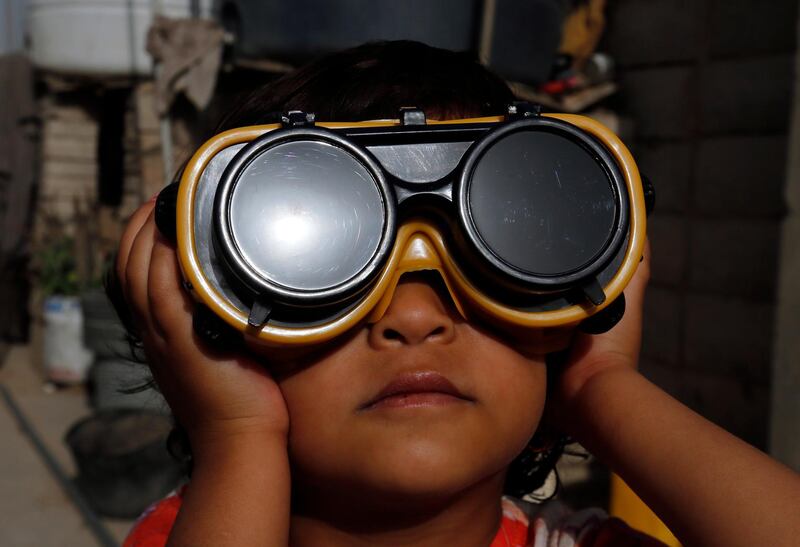 A child uses special protective glasses to observe a partial solar eclipse in Sanaa, Yemen. EPA