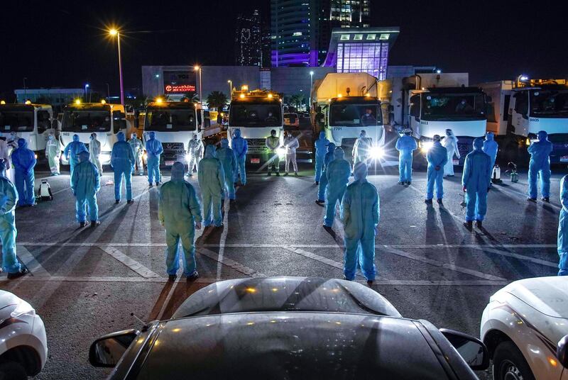 Abu Dhabi, United Arab Emirates, March 27, 2020.   
  Sanitation workers from Tadweer in formation on the first day of the UAE cleaning campaign.  Emiratis and residents across the UAE must stay home this weekend while a nationwide cleaning and sterilisation drive is carried out.
Victor Besa / The National
Section:  NA
Reporter:  Haneen Dajani