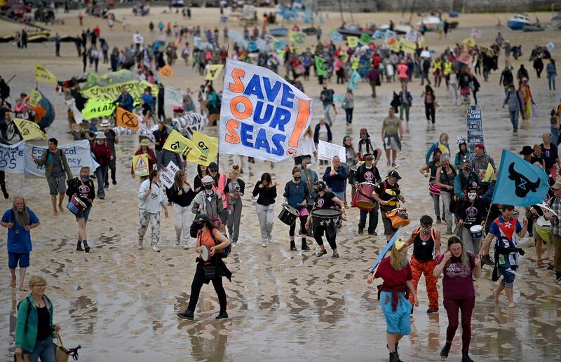 Activists take part in an Extinction Rebellion climate change protest march on the beach in St Ives, Cornwall.