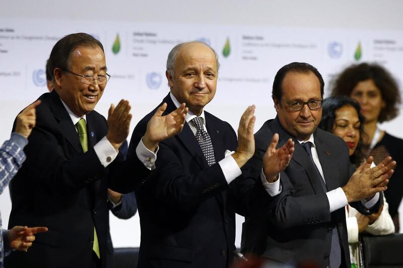 United Nations Secretary General Ban Ki-Moon and other leaders applaud after the final conference at  COP21 (AP Photo/Francois Mori)