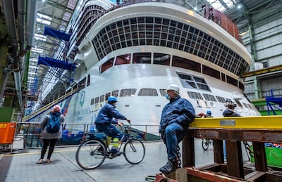 A shipbuilder waits in front of the stern of the Global Dream. AP