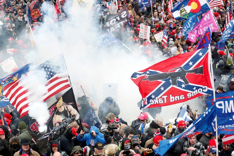 A Confederate battle flag that reads 'Come and Take It' and shows a military-style rifle flies as rioters storm the Capitol on January 6, 2001. Reuters