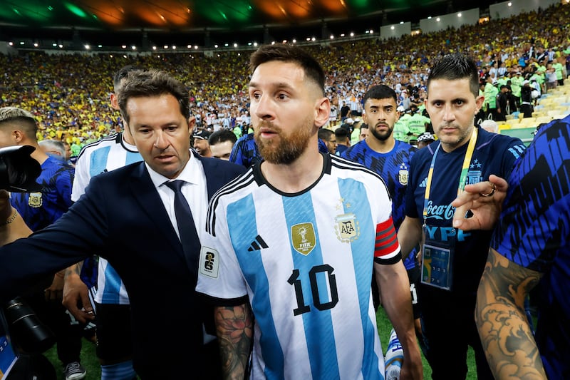 Lionel Messi watches on from the pitch as the match is delayed due to incidents in the stands. Getty Images