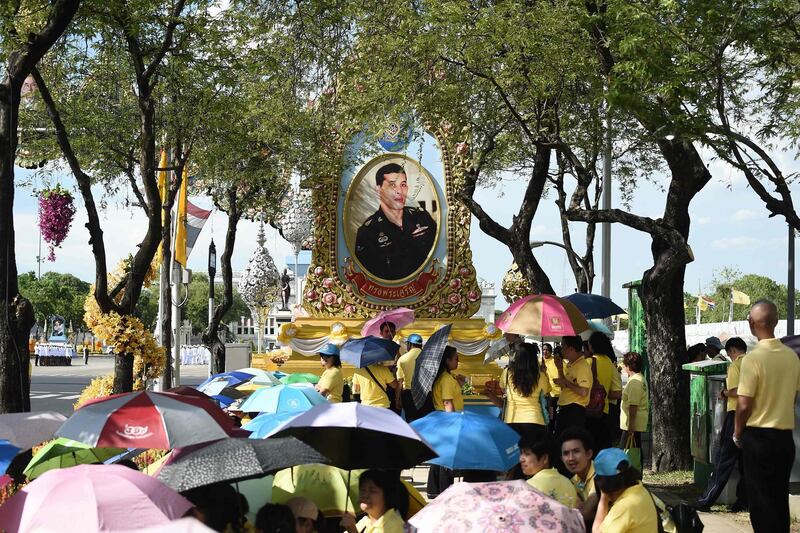 Well-wishers gather in front of a portrait of Thailand's King Maha Vajiralongkorn. AFP