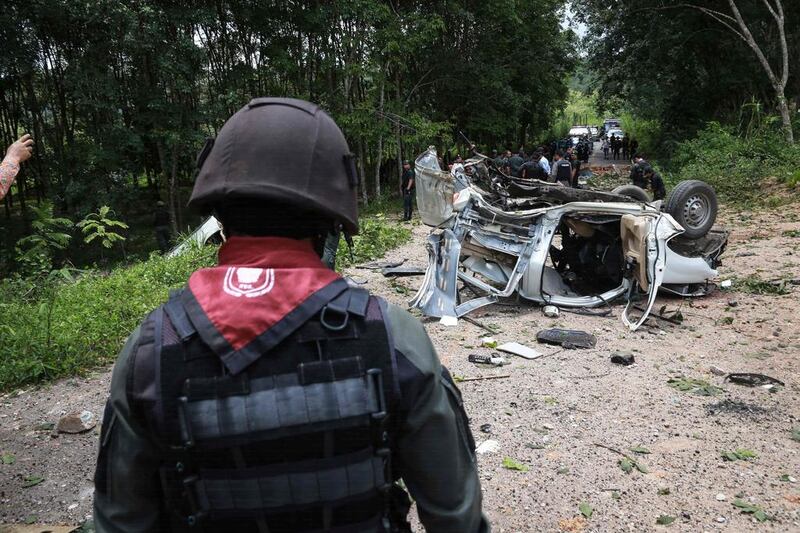 Thai police and army personnel inspect the scene of a bomb attack which left three police officers dead in Thailand’s restive southern province of Yala on September 23, 2016. Katawut Chum / AFP