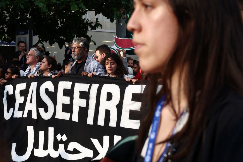 People hold a banner during a protest for climate justice and a cease fire in Gaza. Reuters