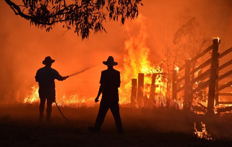 Residents defend a property from a bushfire at Hillsville near Taree, 350km north of Sydney. AFP