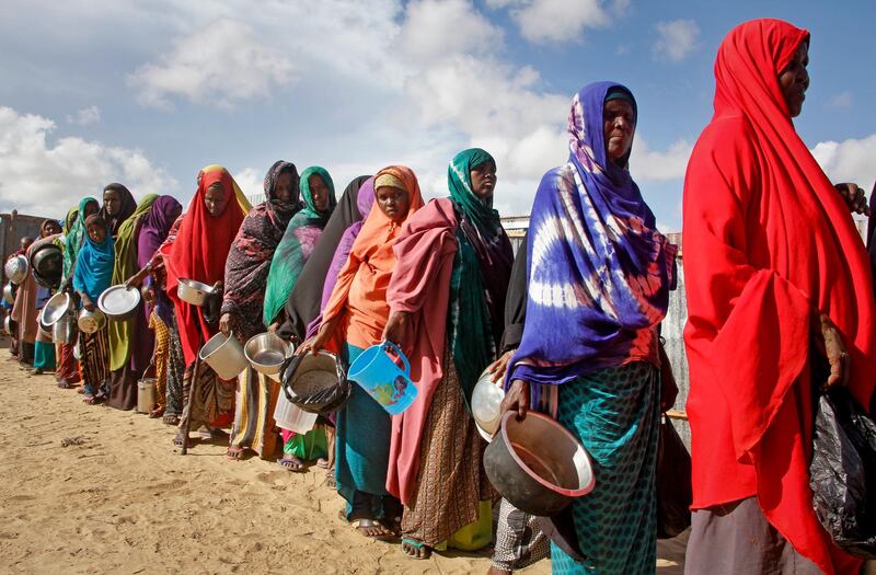 FILE - In this Saturday, May 18, 2019 file photo, newly-arrived women who fled drought line up to receive food distributed by local volunteers at a camp for displaced persons in the Daynile neighborhood on the outskirts of the Somalian capital Mogadishu. On Tuesday, June 5, 2019, a United Nations emergency relief coordinator said more than 2 million men, women and children could die of starvation in Somalia by summer's end if international aid is not sent quickly to the drought-stricken African country. (AP Photo/Farah Abdi Warsameh)