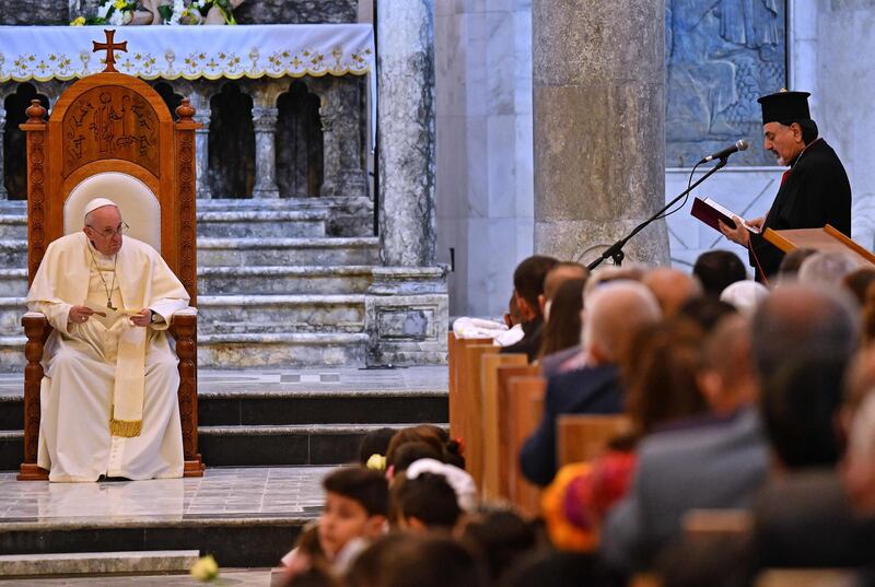 Ignatius Joseph III Yunan, Syriac Catholic Patriarch of Antioch, reads from a book as Pope Francis listens while on the throne at the Syriac Catholic Church of the Immaculate Conception. AFP