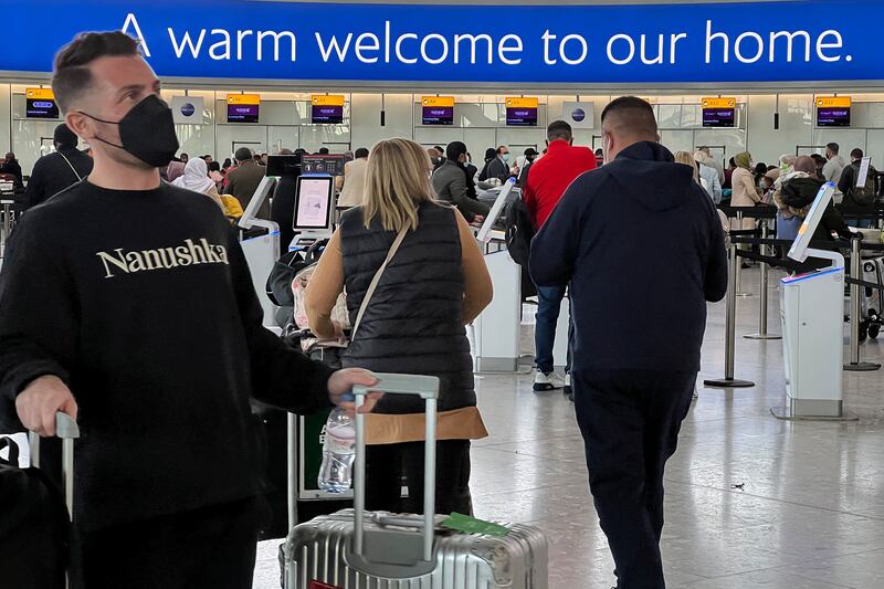 Passengers queue to check in at Heathrow Airport in London.  The new, potentially more contagious Omicron variant of the coronavirus was found in more European countries, days after being identified in South Africa, leaving governments around the world rushing to stop the spread. AP