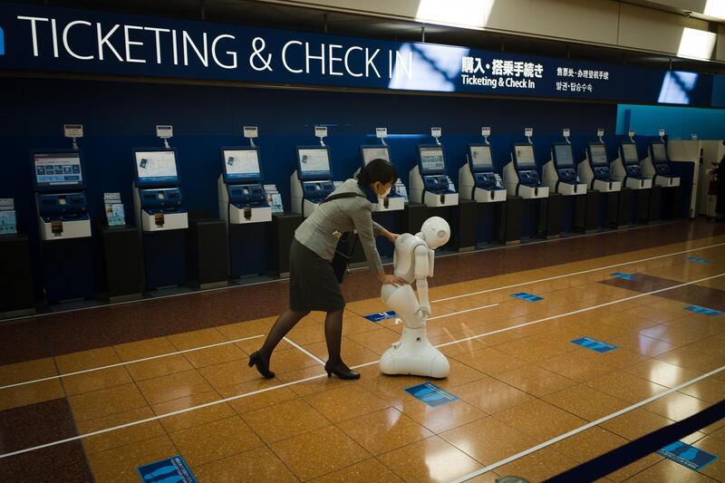 A member of All Nippon Airways Co. ground crew moves a SoftBank Group Corp. Pepper humanoid robot at Haneda Airport departures lobby. The global airline industry is facing a painfully slow recovery from the ongoing effects of the pandemic as carriers slash jobs and secure funds to ride out the crisis. Bloomberg