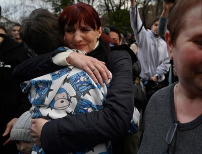 Inessa hugs her son Vitaly after the bus delivering him and more than a dozen other children back from Russian-held territory arrived in Kyiv on March 22. AFP