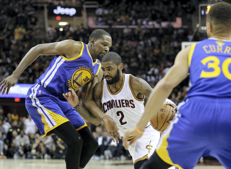 Cleveland Cavaliers guard Kyrie Irving (2) drives between Golden State Warriors forward Kevin Durant (35) and Stephen Curry (30) during the second half of Game 3 of basketball's NBA Finals in Cleveland, Wednesday, June 7, 2017. Golden State won 118-113 (AP Photo/Tony Dejak)