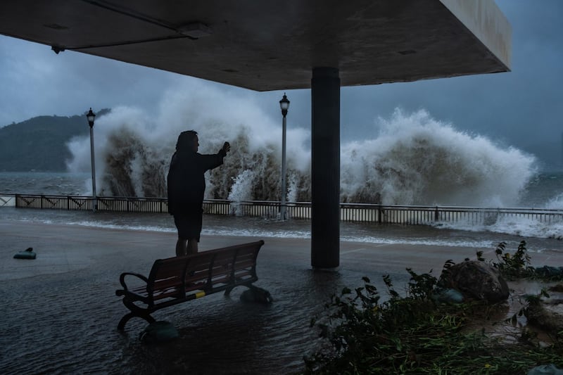 A man takes photograph at the seafront in Hong Kong. Getty Images